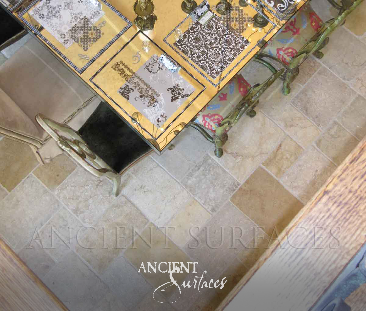 Ancient Surfaces Arcane Limestone small format floor tiles in cream and gold tones seen from above beside gilt chairs
