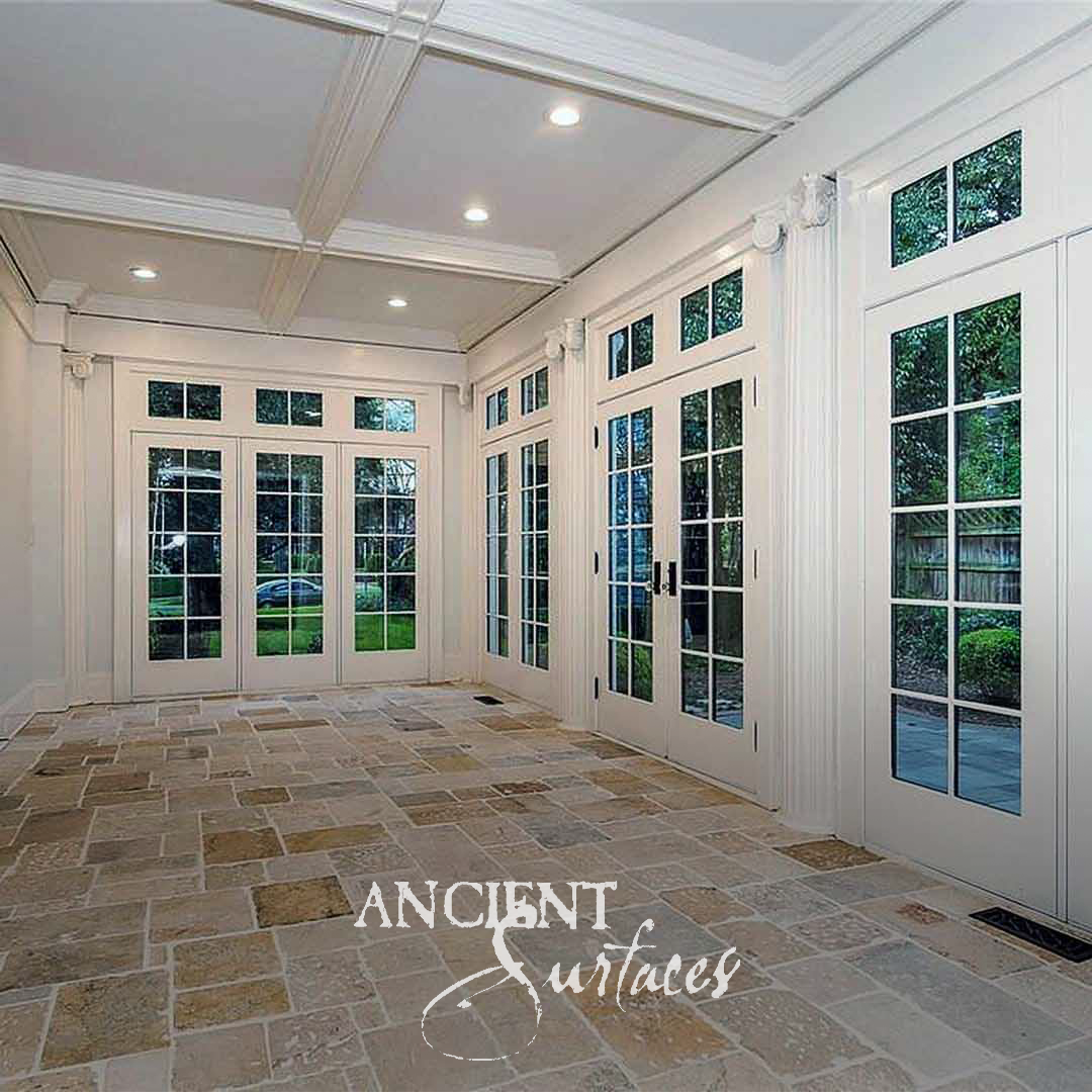 Ancient Surfaces Biblos Limestone flooring in honey and grey tones across a white garden room with glazed doors