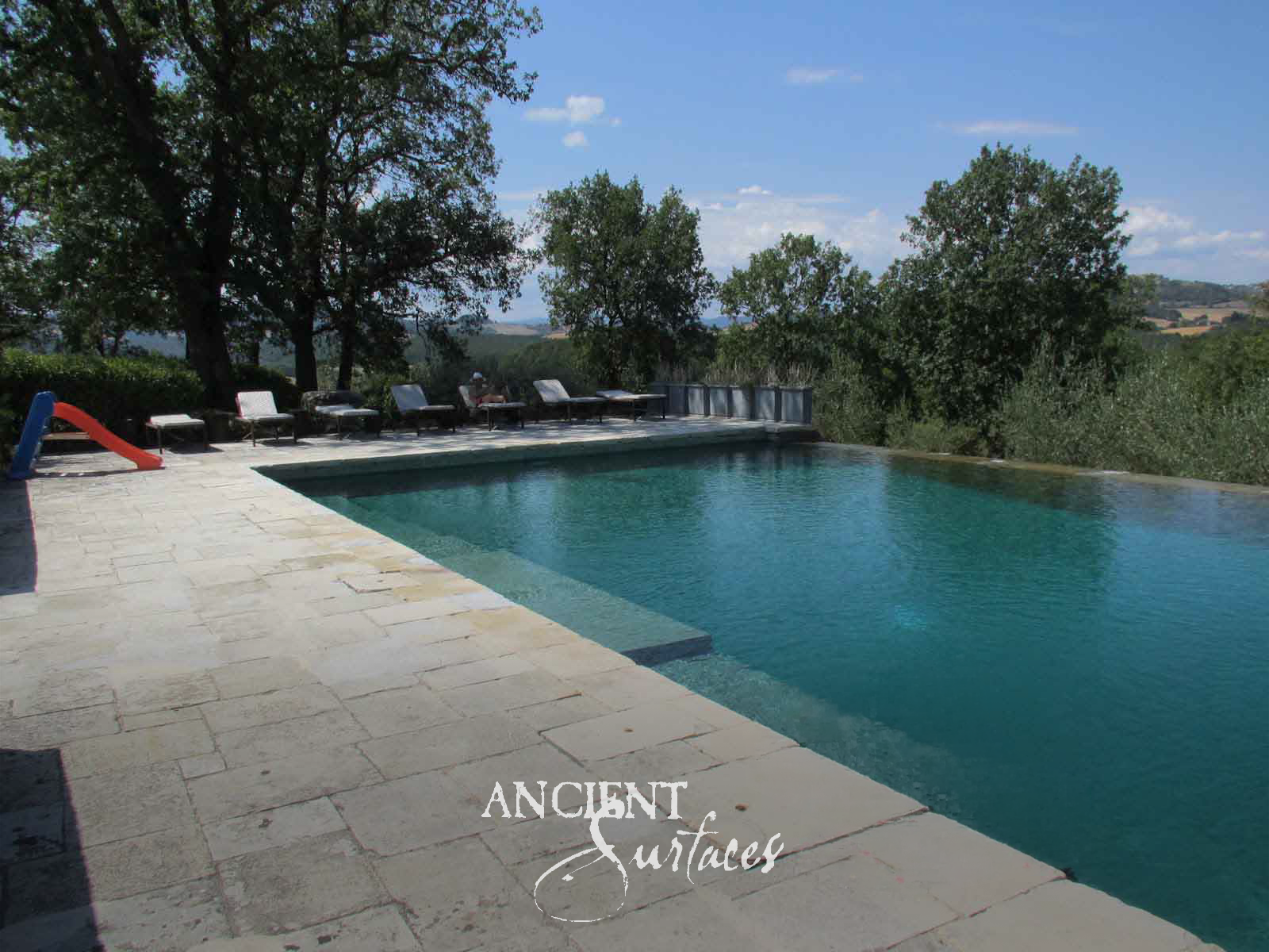 Ancient Surfaces Biblos Limestone paving around an infinity pool on a terrace above an olive planted valley