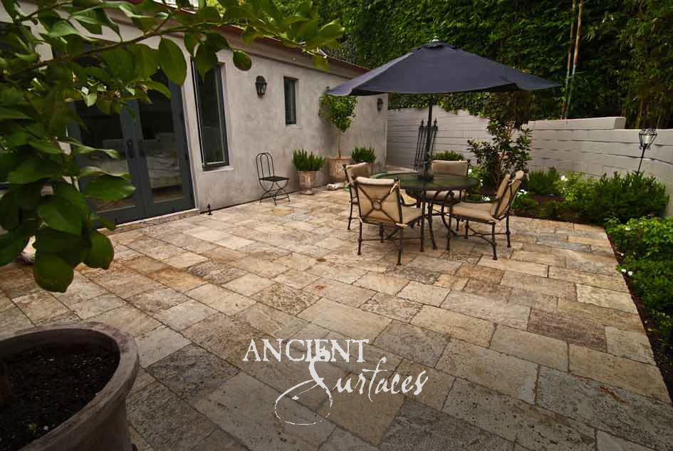 Ancient Surfaces Kronos Limestone paving in silver grey and gold across a walled courtyard terrace