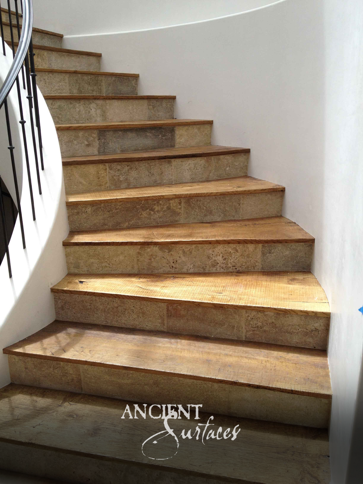 Ancient Surfaces Kronos Limestone stair risers set beneath sawn timber treads on a curving staircase