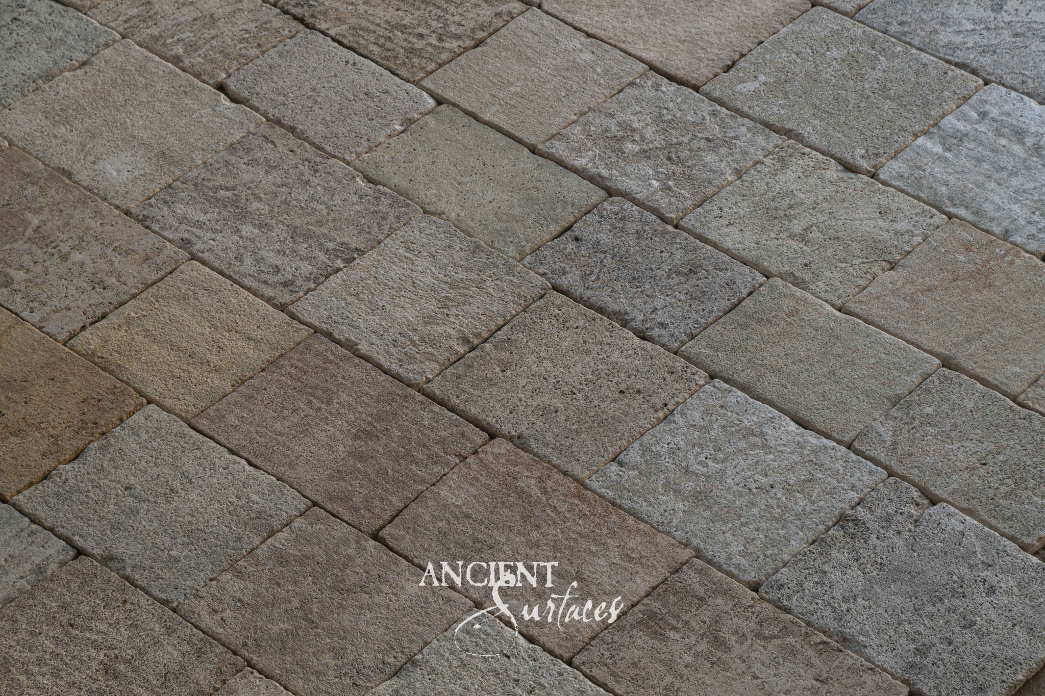 Close view of Ancient Surfaces Kronos Limestone paving showing porous grey and rose toned faces